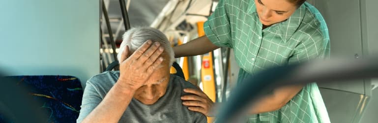 anxious woman consoling senior man on the bus