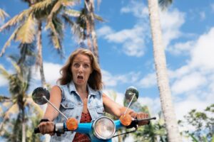 woman surprised while riding vespa