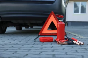 Emergency warning triangle and safety equipment near car