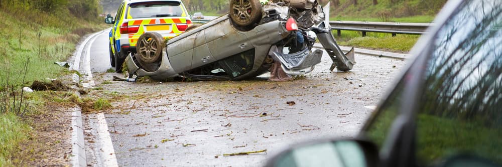 Overturned car after fatal accident on North Carolina highway with emergency responders on scene
