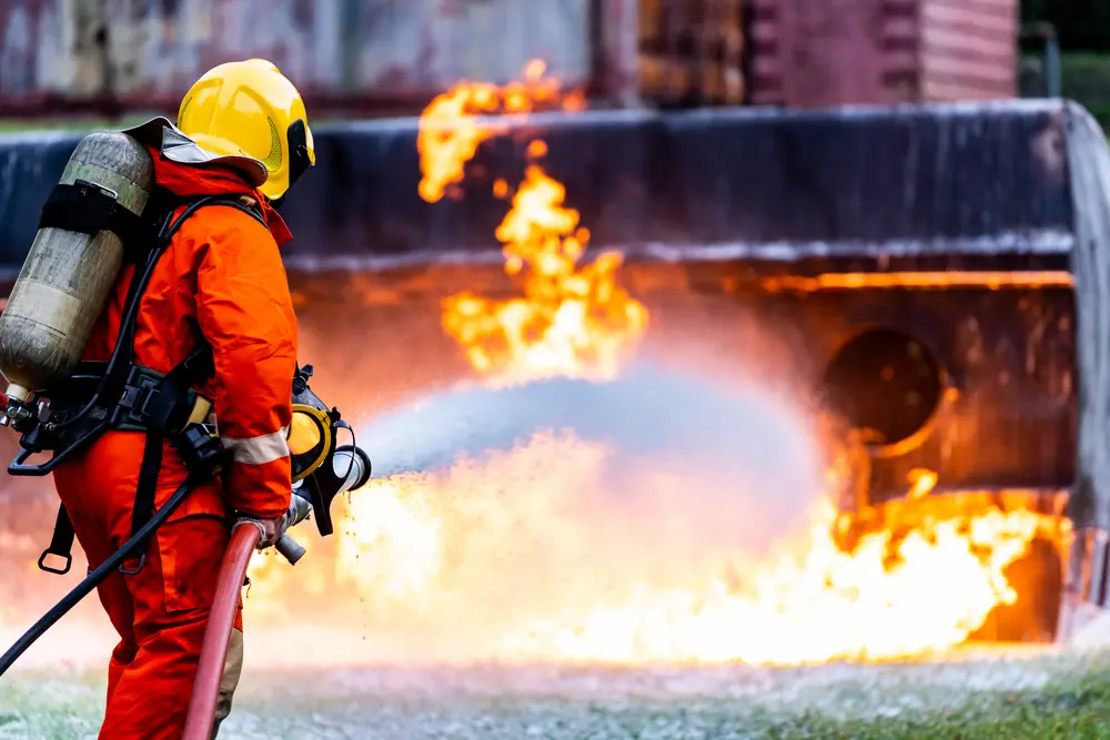 firefightert using chemical foam to extinguish fire