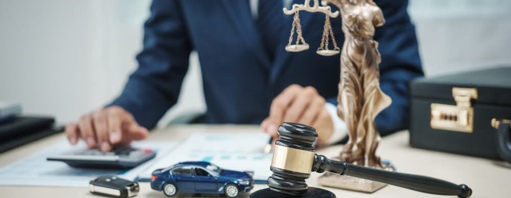 A man in a suit making calculations, representing a work-related car accident lawyer.